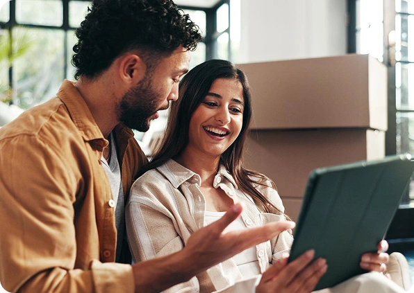 A happy couple looks at a tablet