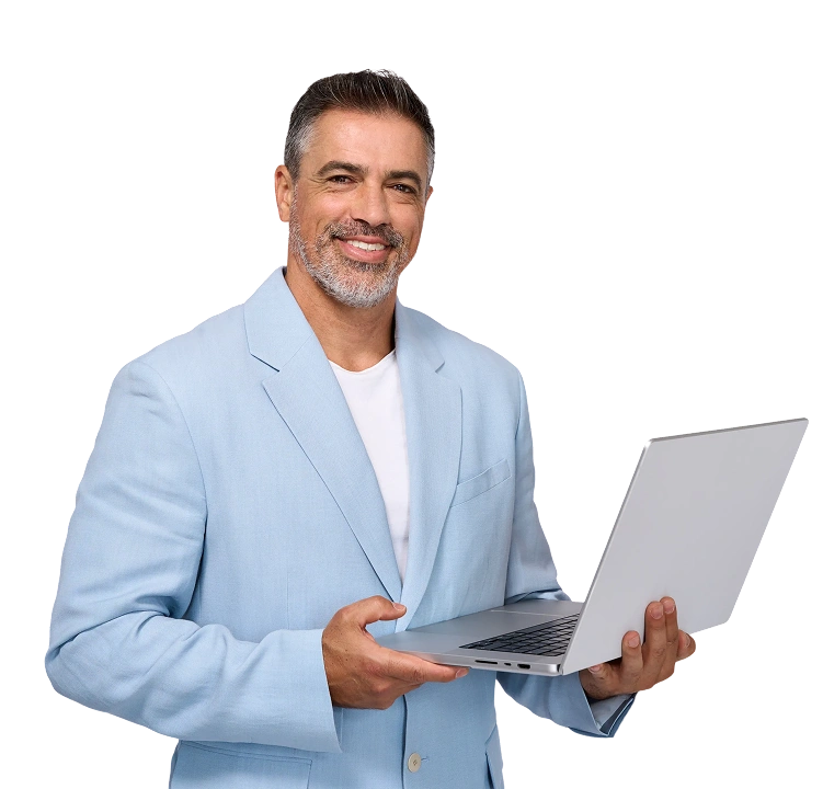 Smiling man in a light blue suit holding a laptop against a black background. The expression conveys confidence and friendliness.